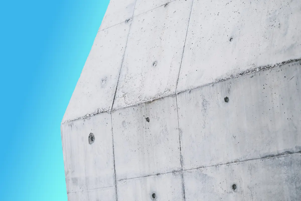 Fachada de betão aparente com marcas de cofragem contra o céu azul